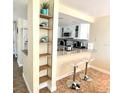 Kitchen view from living area with granite counters and stylish bar stools at 323 Rex Pl # G, Madeira Beach, FL 33708
