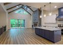 Open-concept living area featuring a stone fireplace, vaulted ceilings, and a modern kitchen at 344 Bay St, Palm Harbor, FL 34683