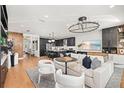 Open-concept living room with modern decor flowing into the kitchen and dining area at 3546 Malta Ave, Wesley Chapel, FL 33543