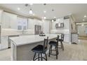 Bright modern kitchen featuring a large center island with seating, stainless steel appliances, and white cabinetry at 4165 San Severo Rd, Wesley Chapel, FL 33543