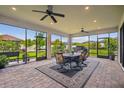 Enclosed patio with brick floors, ceiling fans, and large windows overlooking the backyard at 4165 San Severo Rd, Wesley Chapel, FL 33543