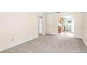 Spacious living room with neutral carpet, light colored walls, and a doorway to the kitchen area at 417 Broadway, Dunedin, FL 34698