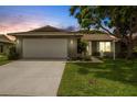 Charming home with a well-manicured lawn and a white garage door in the early evening at 4500 Great Lake S Dr, Clearwater, FL 33762