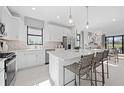 Modern kitchen features white cabinets, stainless steel appliances, and a spacious center island with seating at 4531 Gardner St, Bradenton, FL 34210