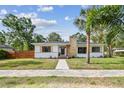 Charming single-story home with a stone chimney, manicured lawn, and inviting walkway at 4560 7Th N Ave, St Petersburg, FL 33713