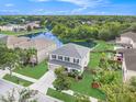 Picturesque aerial shot highlighting a lakeside home with lush landscaping and community amenities like a pool at 5804 Butterfield St, Riverview, FL 33578
