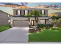 Charming two-story home featuring a well-manicured lawn, beautiful landscaping, and an attached two-car garage at 5804 Butterfield St, Riverview, FL 33578