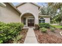 Inviting front entrance with manicured landscaping and double doors with leaded glass at 6038 Palomaglade Dr, Lithia, FL 33547