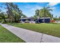 Stylish blue house with a green lawn and sidewalk in a tranquil neighborhood setting at 6110 N Suwanee Ave, Tampa, FL 33604