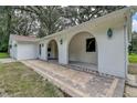 Covered front porch with brick flooring and arched openings to the entry door at 6234 Neff Lake Rd, Brooksville, FL 34601