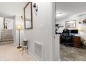 Hallway leading to a staircase and a home office space with wood-look tile at 6420 92Nd N Pl # 1205, Pinellas Park, FL 33782