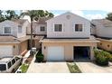 Charming two-story townhome features an attached garage, driveway, and mature plantings at 6980 Ulmerton Rd # 7C, Largo, FL 33771
