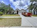 Residential home showcasing a dumpster in the driveway, set against a partly cloudy sky at 7504 Turtle View Dr, Ruskin, FL 33573