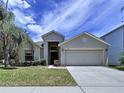 Attractive one-story house with a two-car garage, manicured lawn, and mature palm trees at 7504 Turtle View Dr, Ruskin, FL 33573