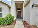 Inviting home entryway featuring a covered porch, neutral paint, and manicured landscaping at 7504 Turtle View Dr, Ruskin, FL 33573