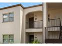 Close up of a two-story condo building exterior with arched entryways and stairwell at 7701 Starkey Rd # 332, Seminole, FL 33777
