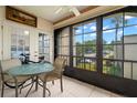 Relaxing patio with a small glass table, chairs, and view of the outdoors through large windows at 7701 Starkey Rd # 332, Seminole, FL 33777
