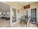 Relaxing patio with a small glass table, chairs, with view to living and kitchen area at 7701 Starkey Rd # 332, Seminole, FL 33777