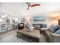 Relaxing living room featuring a large sofa, wooden ceiling fan, and beach-themed artwork at 868 Bayway Blvd # 206, Clearwater Beach, FL 33767