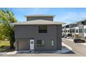 Modern two-story townhouse with gray facade, garage, and well-maintained landscaping at 8723 Palm Ranches Pl, Tampa, FL 33614