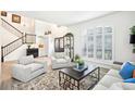 Bright living room with a soaring ceiling, plantation shutters, and a staircase with an iron railing at 9203 Meadow Lane Ct, Tampa, FL 33647