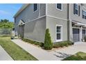 Beautiful gray townhome exterior showing the side, with trimmed evergreens and a sidewalk at 9665 Sweetwell Pl, Riverview, FL 33569