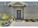 Inviting front entrance with wreath, landscaping, gray door and concrete entry at 9665 Sweetwell Pl, Riverview, FL 33569