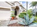 Close-up of home's front exterior showcasing desert landscaping, arched entry and two-car garage at 10357 Lightner Bridge Dr, Tampa, FL 33626