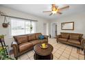 Inviting living room featuring tile flooring, a cozy seating arrangement, and a stylish ceiling fan at 1101 Essex N Dr, St Petersburg, FL 33710
