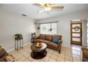 Comfortable living room with tile floors, a cozy sofa, and ample natural light from the large window at 1101 Essex N Dr, St Petersburg, FL 33710