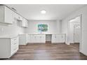 Bright and airy kitchen featuring white cabinets and countertops with wood-look flooring at 1108 E Annie St, Tampa, FL 33612