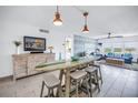 Open-concept living room boasts a surfboard dining table, white tile floors, and stylish coastal decor at 1120 N Shore Ne Dr # 804, St Petersburg, FL 33701