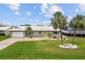 Charming single-story home with a well-manicured lawn, white roof, and a bright yellow front door at 113 16Th St, Belleair Beach, FL 33786
