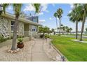Inviting walkway leading to a charming home with mature landscaping and serene waterfront views at 113 16Th St, Belleair Beach, FL 33786