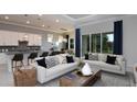 Bright living room with couches, modern lighting, and a large sliding glass door showcasing the backyard at 11443 Shoreline Trl, Parrish, FL 34219