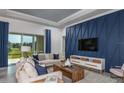 Cozy living area featuring a stylish accent wall, comfortable seating, and a sliding glass door to the patio at 11443 Shoreline Trl, Parrish, FL 34219