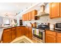 Well-equipped kitchen features stainless steel appliances and wooden cabinetry at 12456 Spreading Oak Dr, Spring Hill, FL 34609