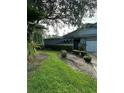 Shows the blue house and front yard, including a lawn and driveway at 135 Pinewinds Blvd, Oldsmar, FL 34677