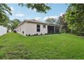 The backyard features a lush lawn and a screened-in lanai, perfect for outdoor entertaining at 13813 Sigler St, Riverview, FL 33579