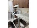 Galley kitchen featuring wood cabinets, white appliances, and marble-look countertops at 19029 Us Highway 19 N # 2-23, Clearwater, FL 33764