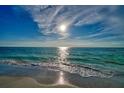 Waves gently lapping onto the sandy beach on a sunny day with sparkling sun reflecting on the water at 19530 Gulf Blvd # 4A, Indian Shores, FL 33785