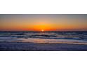Vibrant sunset over the ocean with gentle waves and a sandy beach in the foreground at 19530 Gulf Blvd # 4A, Indian Shores, FL 33785