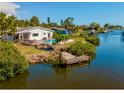 Waterfront home featuring a pool, dock, and screened lanai with direct access to a canal at 1980 Forked Creek Dr, Englewood, FL 34223