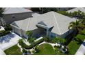 Inviting home featuring a well manicured lawn, decorative plants, and neutral-colored tile roof at 2220 Elizabeth Way, Dunedin, FL 34698