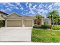 Charming single-story home features a well-manicured lawn and a three-car garage at 2220 Elizabeth Way, Dunedin, FL 34698