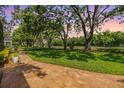 Picturesque backyard featuring a brick paver patio and well-manicured lawn and mature trees at 2769 St Andrews Blvd, Tarpon Springs, FL 34688