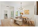 Bright dining room features modern chandelier, light wood floors, and a bench seat for comfortable dining at 2814 Graphite Ct, Valrico, FL 33594