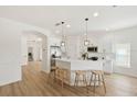 Open kitchen with white cabinets, stainless steel appliances, and a breakfast bar with pendant lighting at 2814 Graphite Ct, Valrico, FL 33594