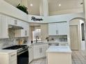 Bright, spacious kitchen with white cabinets, island, stone backsplash, and stainless steel appliances at 29228 Yarrow Dr, Wesley Chapel, FL 33543