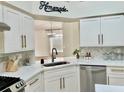 Bright kitchen with modern cabinets, stainless steel appliances, island and quartz countertops at 29228 Yarrow Dr, Wesley Chapel, FL 33543